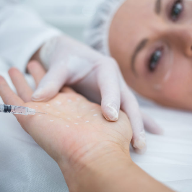 Close-up of doctor injecting woman on her palm