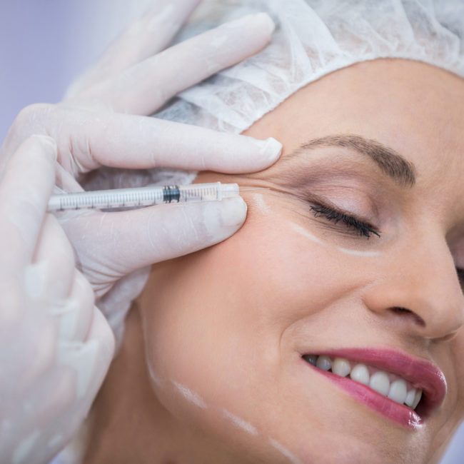 Close-up of woman receiving botox injection at clinic